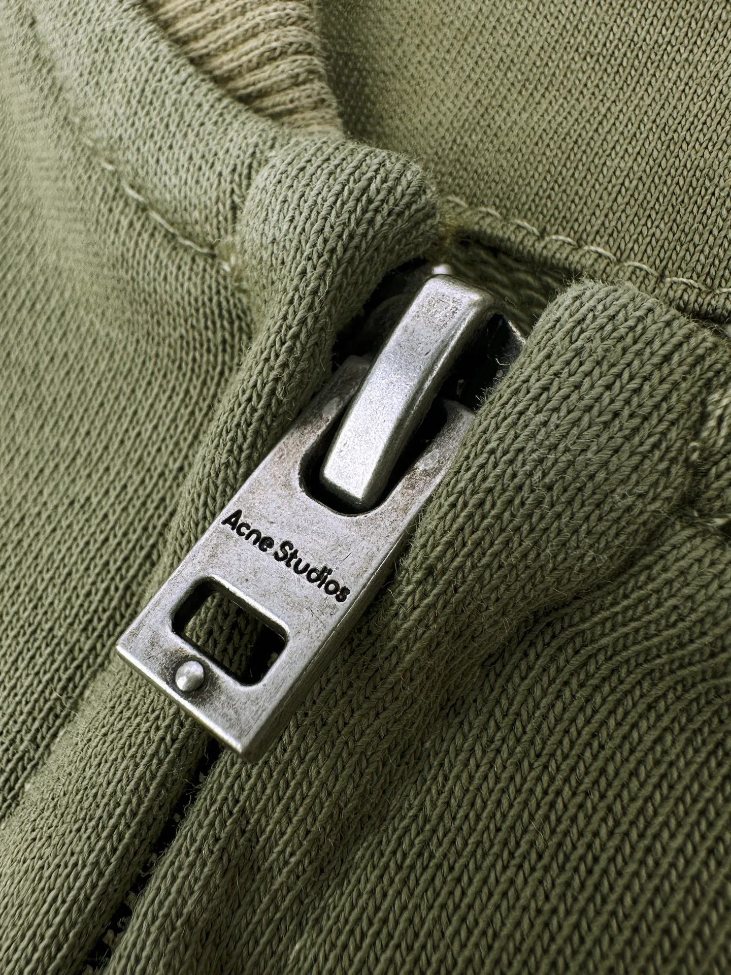 Acne Studios spray-painted distressed logo baseball collar jacket, custom-ordered soft velvet fleece cotton, crisp and smooth, skin-friendly and soft, olive green like mist between pine trees, matte matte surface flowing with warm and luxurious light, showing high-end restrained texture. Classic baseball collar zipper jacket has a neat and elegant silhouette, dropped shoulder tailoring for stretch and casualness, densely woven ribbing to show craftsmanship details, Acne Studios logo printing on the chest, engraving the brand heritage with Retro sports aesthetics Unobtrusive yet recognizable, it combines the Nordic minimalist style with the Retro sports style. It is low-key and elegant, with its own aura. Process 1: Using glue printing technology. The chest printing has been modified three times with the film screen. Use glue liquid paint to print the pattern on the fabric. Bake the fabric to fix the printed pattern. Technique 2: Gradient distressed spray-on process. By spraying dyes of different colors on the surface of the fabric, the clothes can show rich color changes under different lights and increase the visual layering. Process 3: Many parts of the body of the garment are worn by pure manual regular positioning and manual brushing. Texture and depth are added to the surface of the clothing to imitate the texture of natural wear. Process 4: The fabrics are fermented and washed for a better hand feel. Not easy to deform, not easy to shrink, not easy to fade, and maintain long-term beauty. Accessories: Customized 1:1 Acne zipper Customized 1:1 Acne trademark Version: Loose version Size: S M L XL Style number: CC